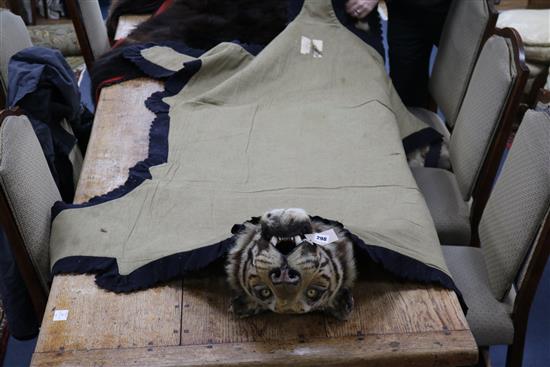 A tiger skin rug, complete with head and claws